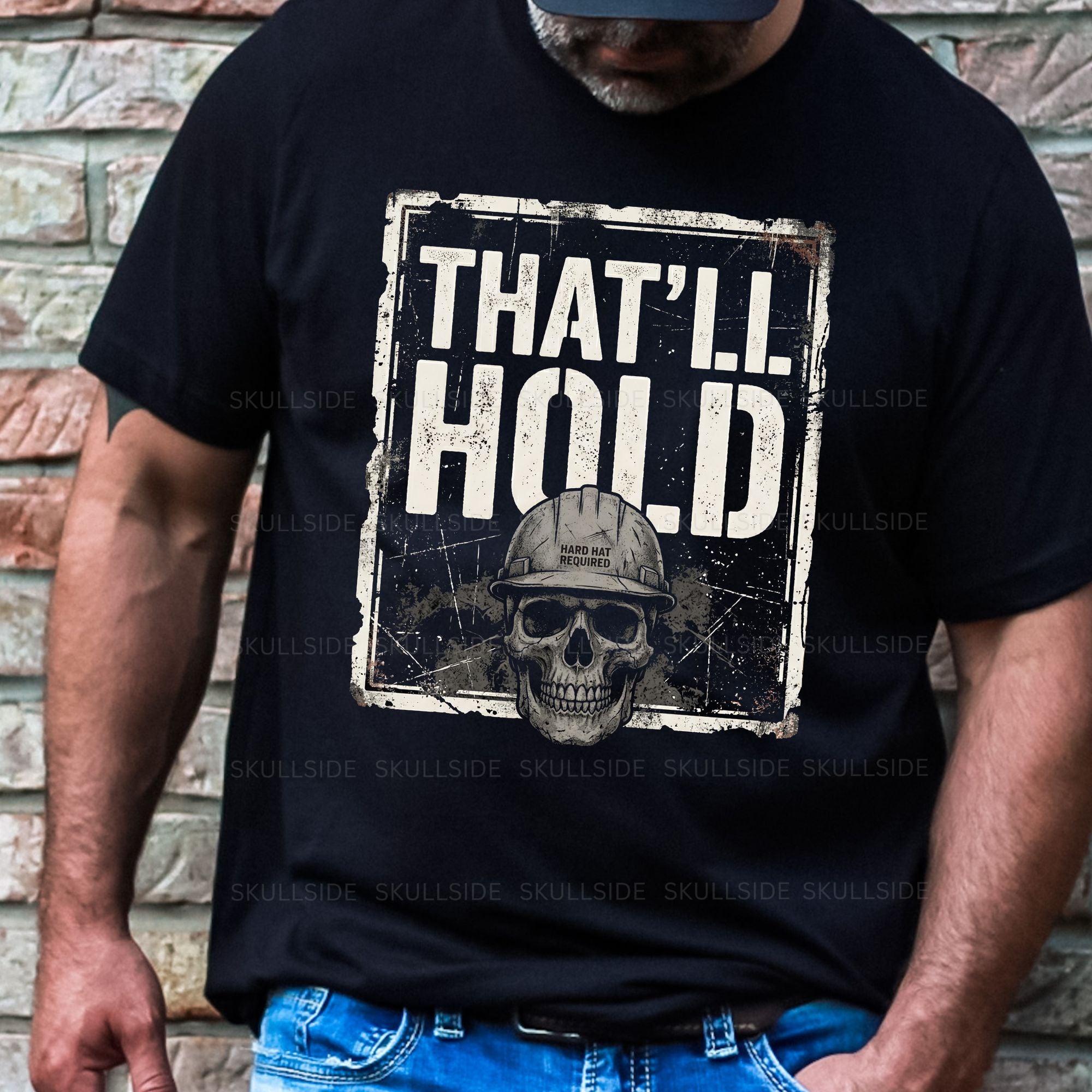 Person wearing a black t-shirt with a skull graphic and text 'THAT'LL HOLD' against a brick wall.